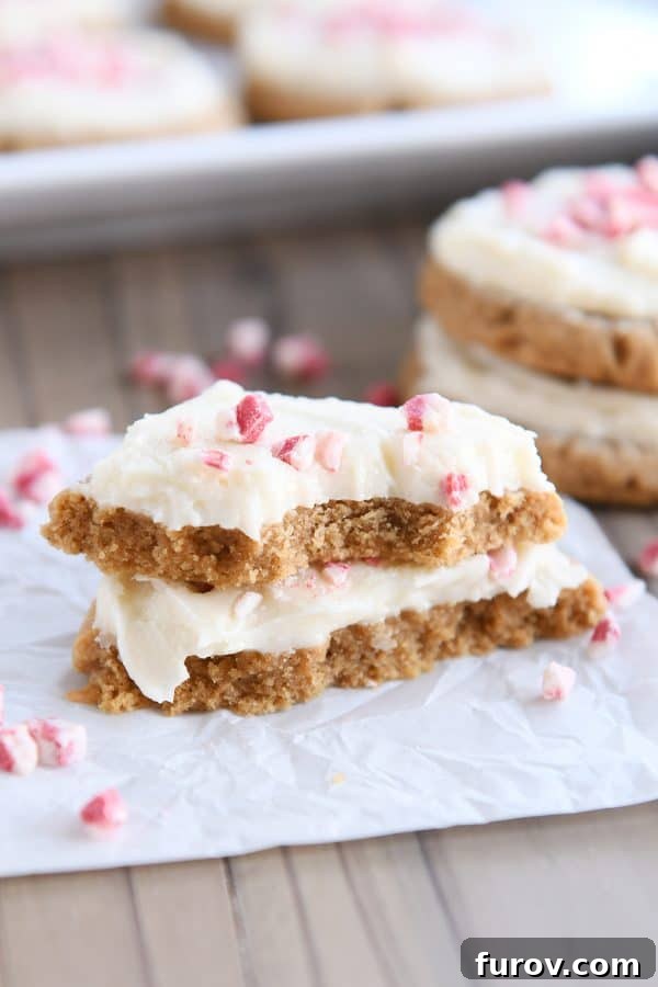 Soft gingerbread sugar cookie broken in half and stacked on white parchment paper.