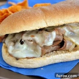 Close-up of a homemade cheesesteak sub with melted provolone cheese.