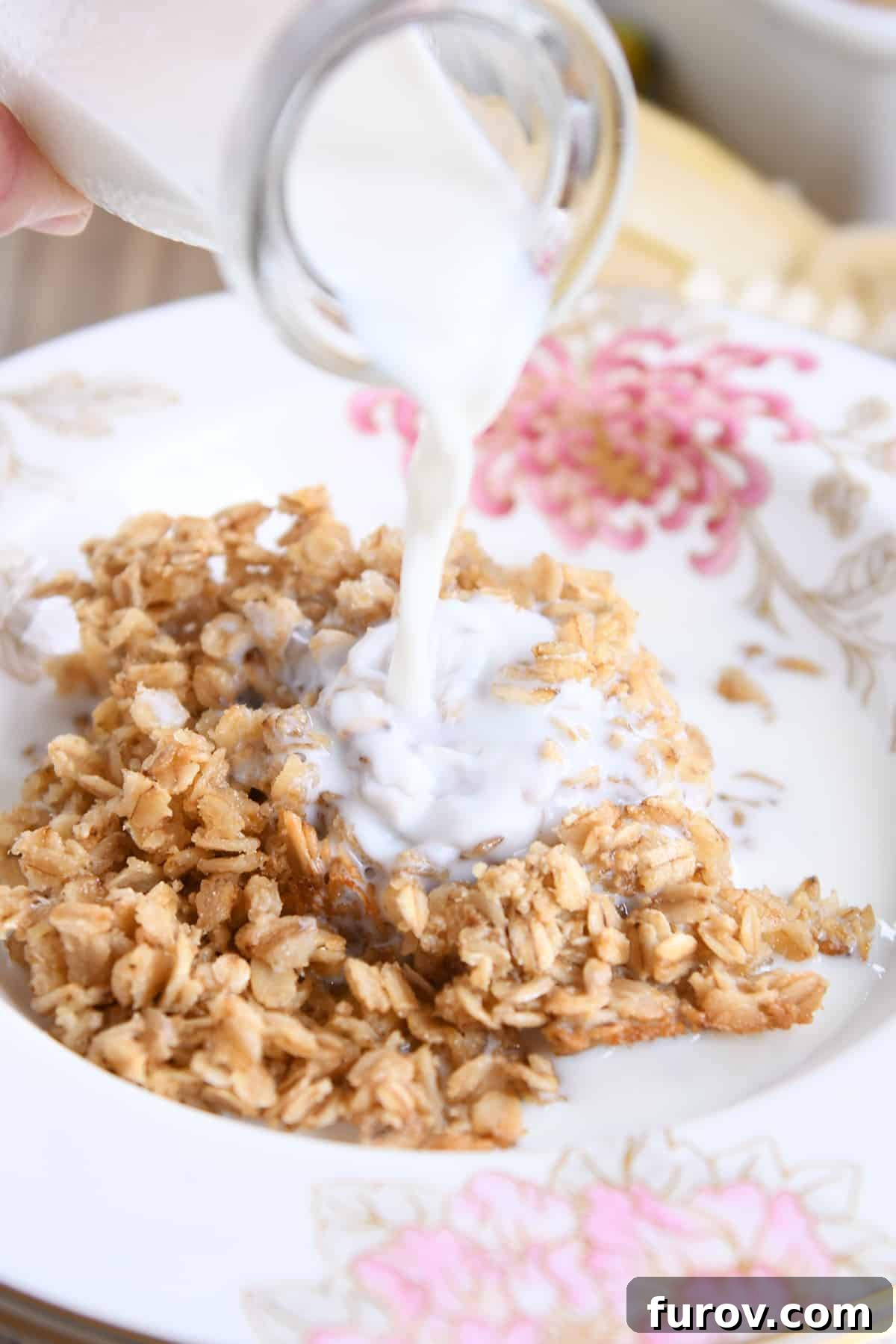 Fresh milk being poured over a warm, inviting bowl of easy Amish baked oatmeal, ready to be enjoyed.
