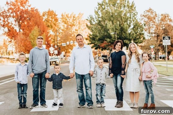 A family of eight, mom, dad, and six children, holding hands and walking together, symbolizing family unity and support.