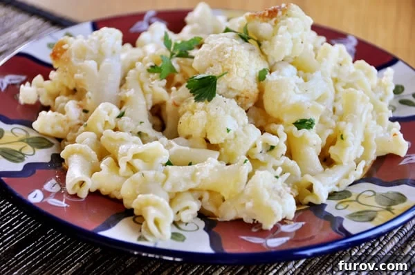 Roasted cauliflower and pasta on a colored plate, ready to be served.
