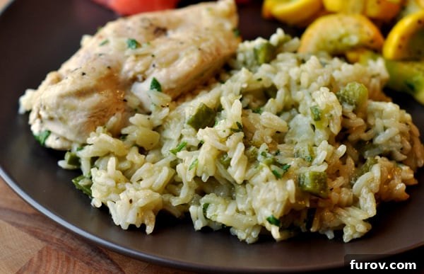Zesty Skillet Chicken with Vibrant Mexican Green Rice 3 Black plate with a generous portion of Mexican green rice and slices of tender cooked chicken.