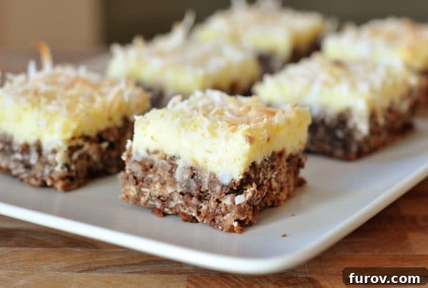 White platter with squares of cream cheese chocolate bars, rich with chocolate and coconut.