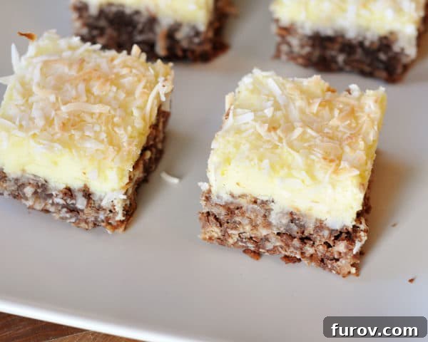 Top view of coconut-topped cream cheese haystack squares on a white platter, ready to be served.