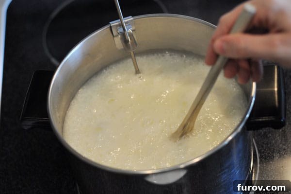 Butter and sugar mixture being stirred in a pot with a wooden spoon, starting to heat up and bubble.