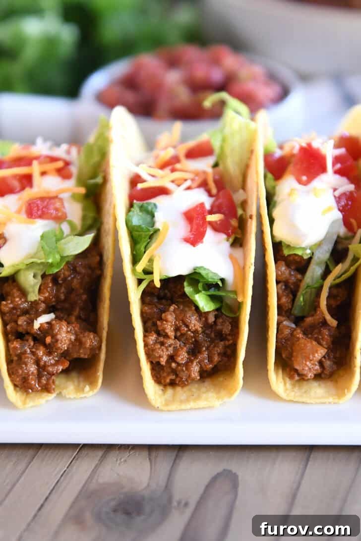 A close-up, top-down view of a white bowl brimming with richly seasoned ground beef taco meat, showcasing its texture and vibrant color, ready for serving.