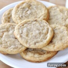 Chocolate Toffee Crunch Cookies 5 A top down view of a white plate full of toffee studded cookies.