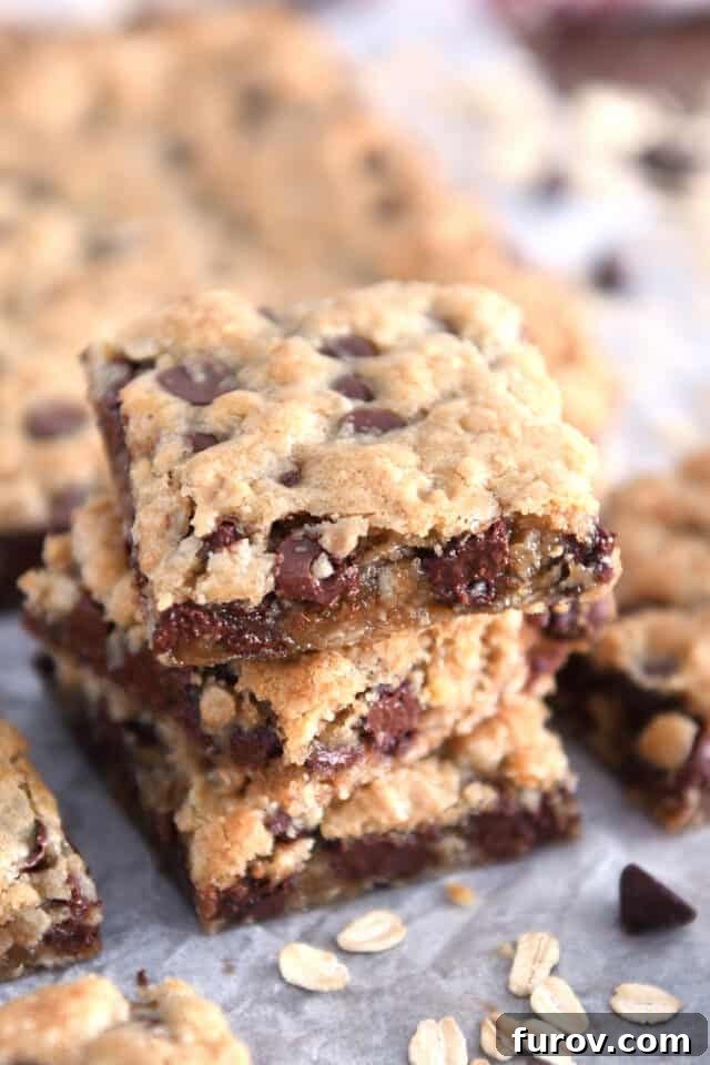 Homestyle Oatmeal Chocolate Chip Cookie Bars 2 Three stacked square oatmeal chocolate chip cookie bars, showcasing their golden-brown edges and melted chocolate chips.