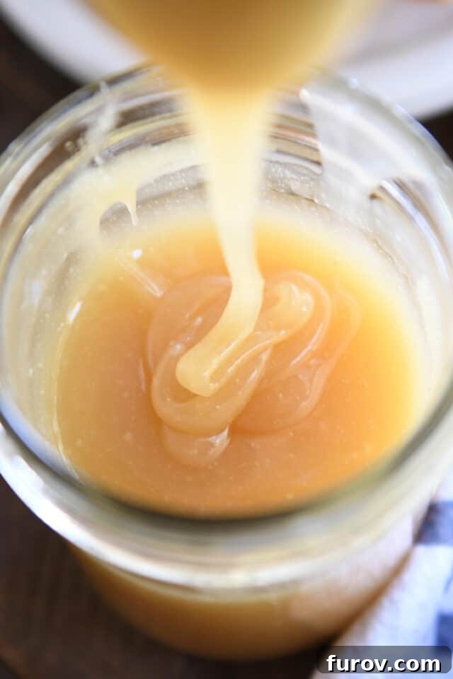 Velvety Buttermilk Caramel 2 Caramel syrup drizzling into glass jar.