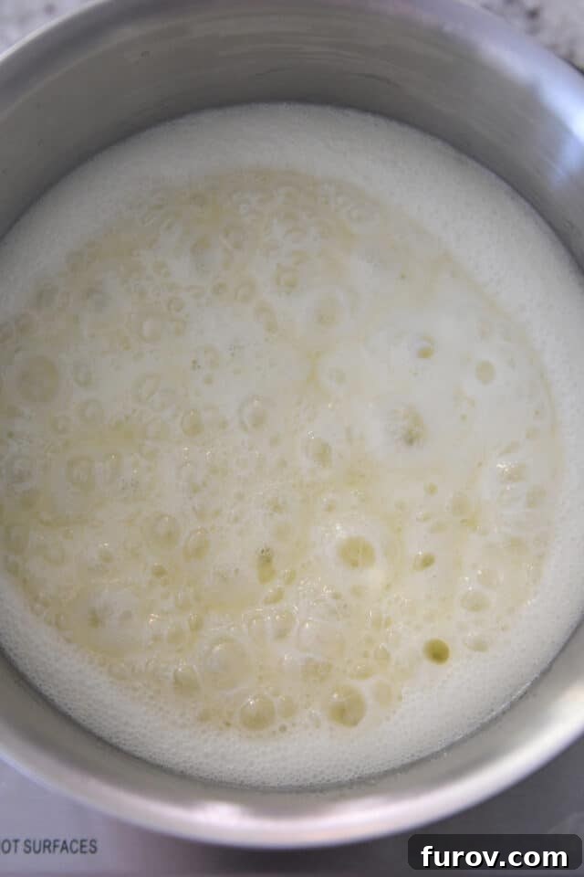 Velvety Buttermilk Caramel 4 Cream colored syrup bubbling in saucepan.