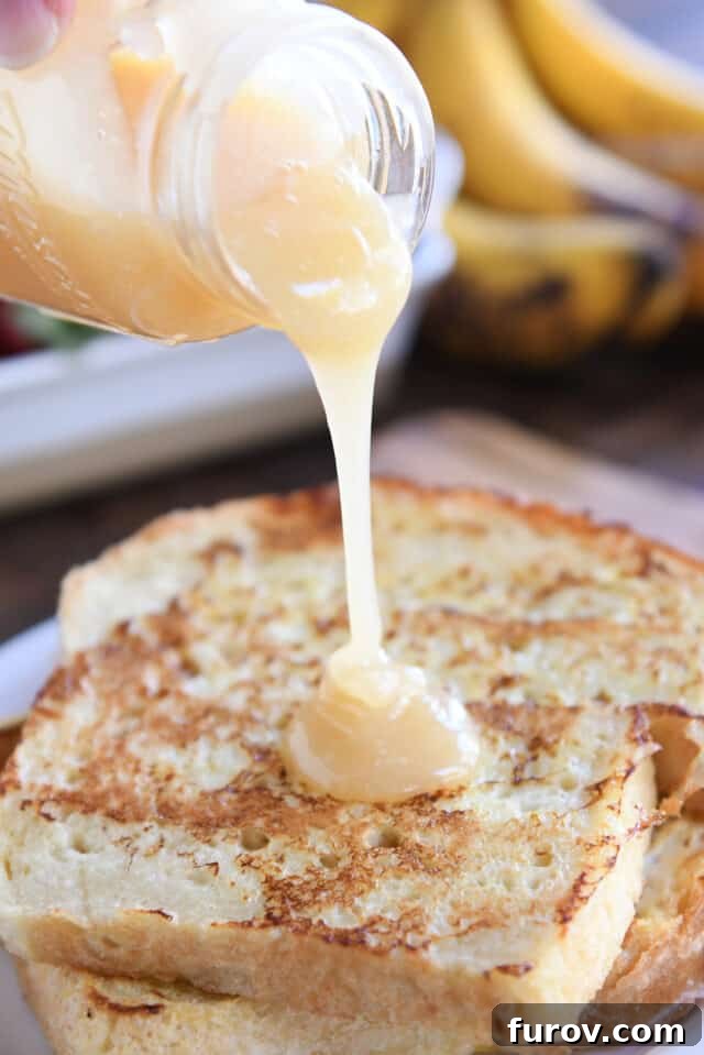 Velvety Buttermilk Caramel 8 Pouring cream colored syrup over two pieces of French toast on white plate.
