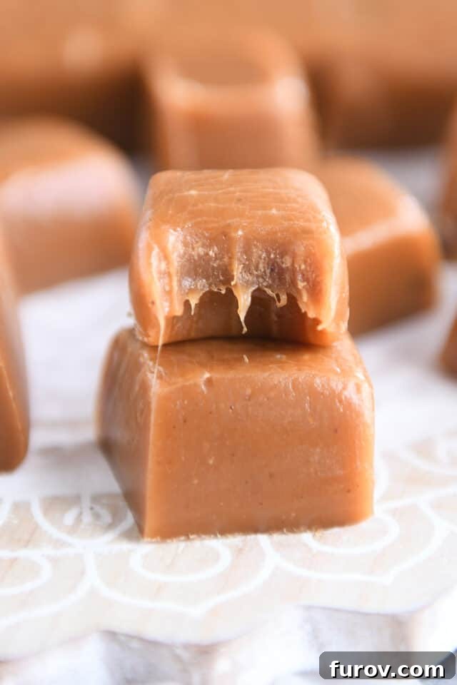 Two gingerbread caramels stacked with a bite taken out of the top caramel, showcasing its soft, chewy texture.