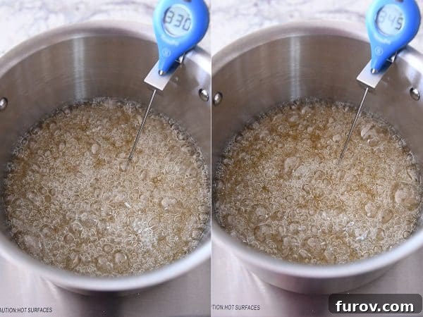 Sugar, corn syrup, and water boiling gently in a saucepan, beginning to take on a light amber color.