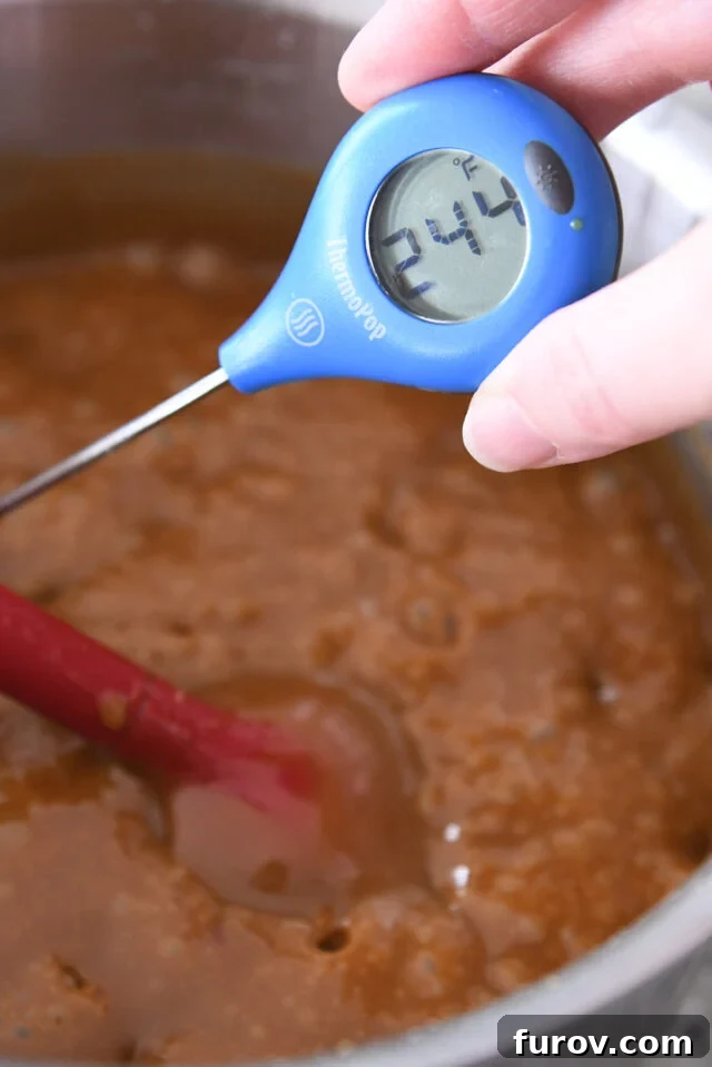 An instant-read thermometer displaying a reading of 244 degrees F, indicating the ideal temperature for soft, chewy caramels.