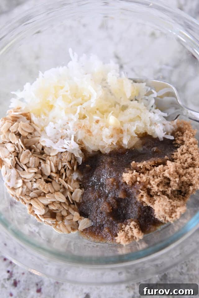 Glass bowl with oats, coconut, brown sugar and butter.
