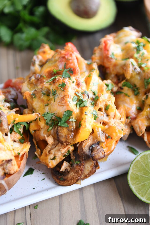 Zesty Chicken Fajita Sweet Potato Bowls 2 Mushrooms and bell peppers and broiled cheese on sweet potatoes, ready to be served.
