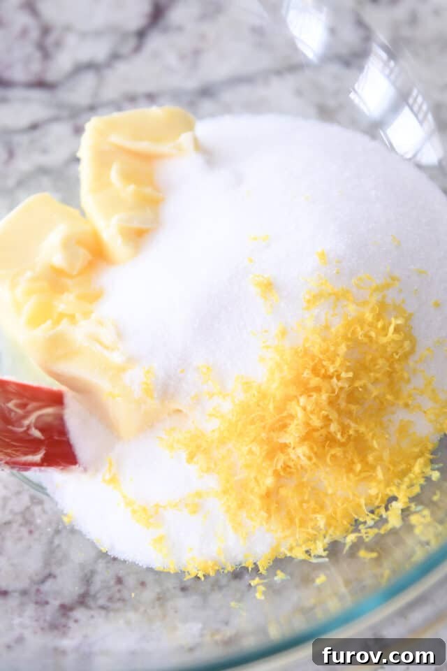 Soft & Chewy Lemon Drop Cookies: So Easy! 4 Softened butter, granulated sugar, and lemon zest in a glass mixing bowl, ready to be creamed.