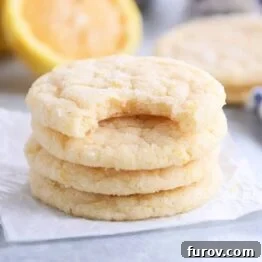 Three and a half stacked lemon sugar cookies on parchment paper.