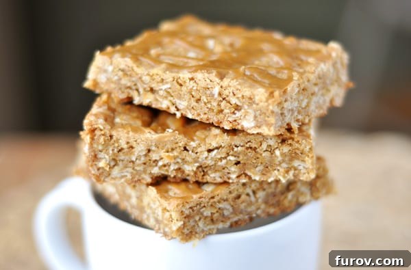 Oatmeal Butterscotch Bars artfully stacked on a white mug, showcasing their golden hue.