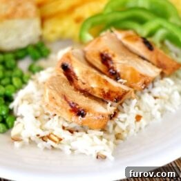 Grilled Teriyaki Chicken slices with rice and green peas.