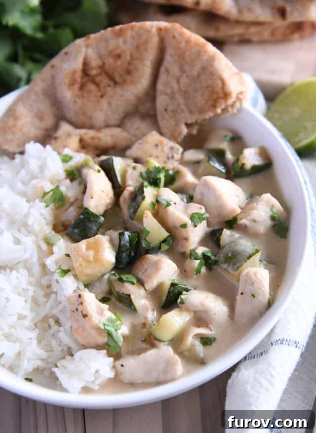 Vibrant Coconut Lime Chicken and Zucchini 2 White bowl with pieces of chicken and zucchini in cream sauce over white rice. A perfectly plated creamy coconut lime chicken and zucchini dish.