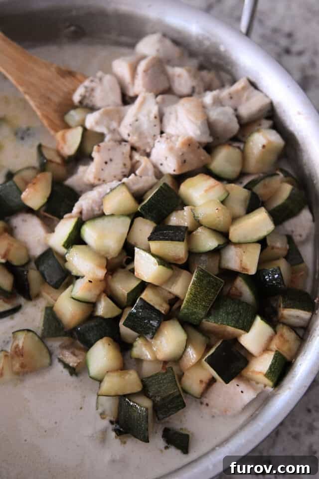 Vibrant Coconut Lime Chicken and Zucchini 4 Chicken and zucchini in skillet with coconut cream sauce. A delicious close-up of the chicken and zucchini simmering in the creamy coconut lime sauce.