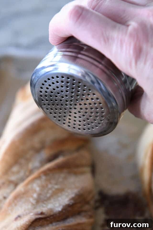 Sprinkling cinnamon sugar mixture on top of bread.