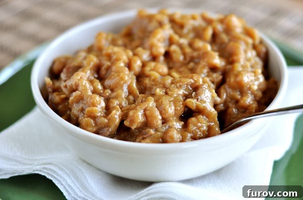 Faster Boston Baked Beans 2 A white bowl full of boston baked beans, perfectly cooked and ready to serve.