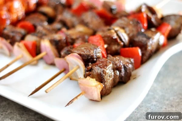 Sizzling Steak and Garden Skewers 3 Close-up of grilled beef and vegetable kebabs on a white platter, showcasing the beautiful char.