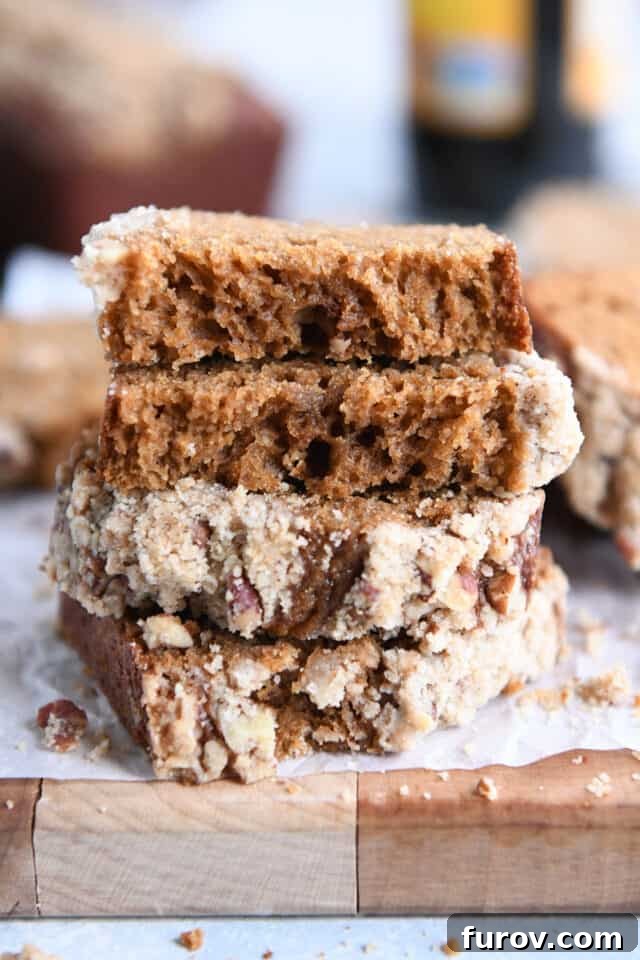 Two halves of a mini gingerbread loaf stacked on top of each other, showcasing the beautiful crumb and streusel topping.