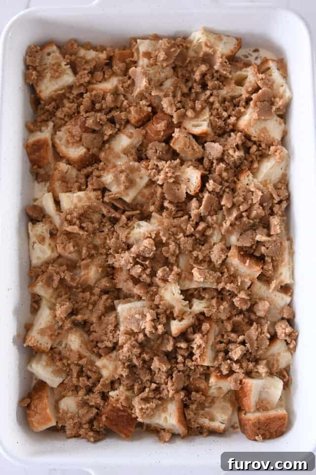 Cinnamon Streusel French Toast Casserole 5 White pan with bread cubes, milk and egg mixture and cinnamon streusel.
