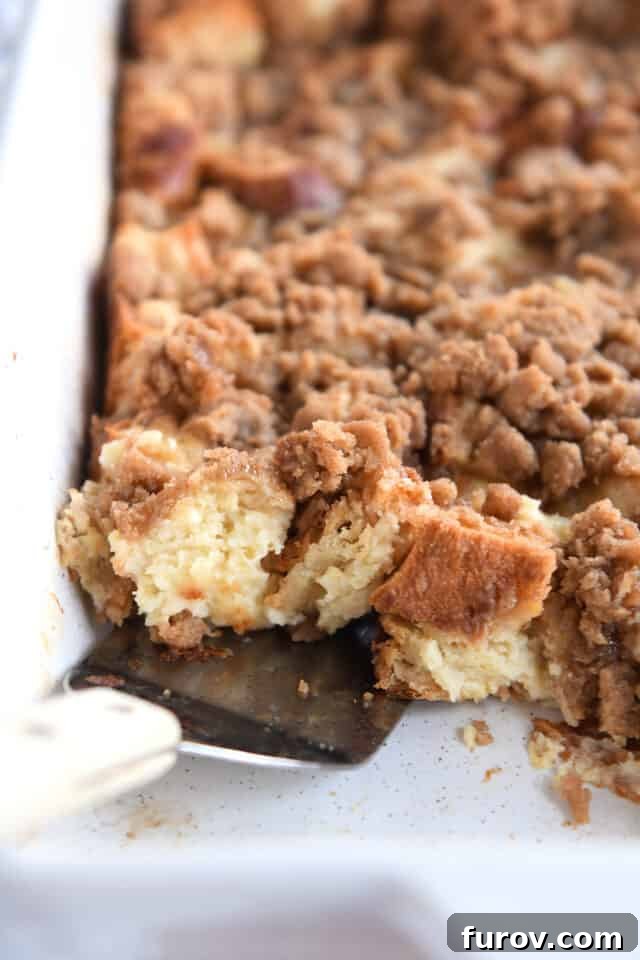 Cinnamon Streusel French Toast Casserole 8 Spatula scooping up French toast bake in white pan.
