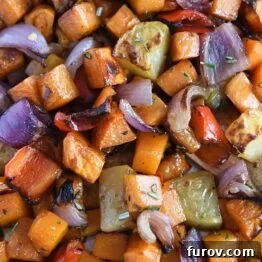 Roasted potatoes, red onions, red bell peppers and butternut squash on sheet pan.
