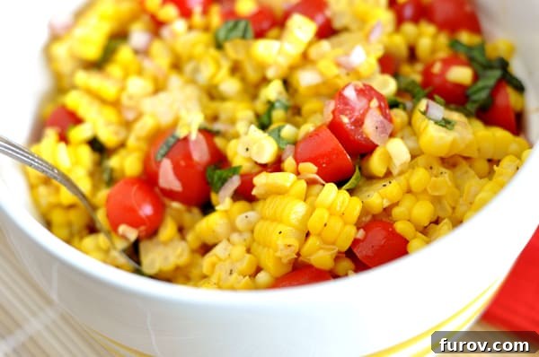 Vibrant white bowl featuring a fresh corn, cherry tomato, and basil salad, ready to serve.