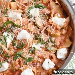 Skillet vegetable lasagna cooked in stainless skillet with dots of ricotta cheese.