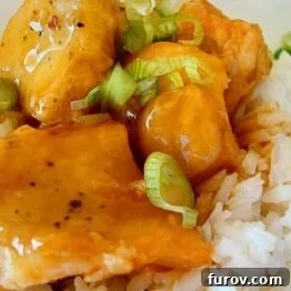 Small dish of baked orange chicken sauce for the recipe.