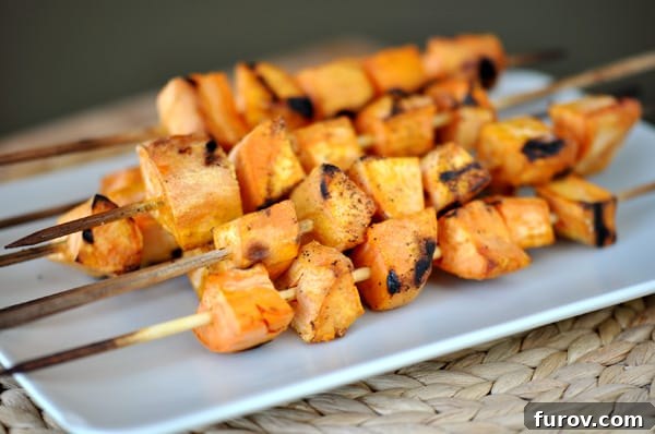 White platter with golden-brown grilled sweet potato skewers, ready to serve.
