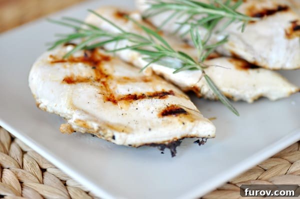 Rosemary Buttermilk Charred Chicken 3 Close-up of grilled chicken breasts with fresh rosemary sprigs, emphasizing the texture and seasoning.