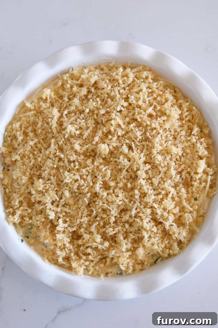 Top down view of unbaked jalapeno popper dip in white pie plate.