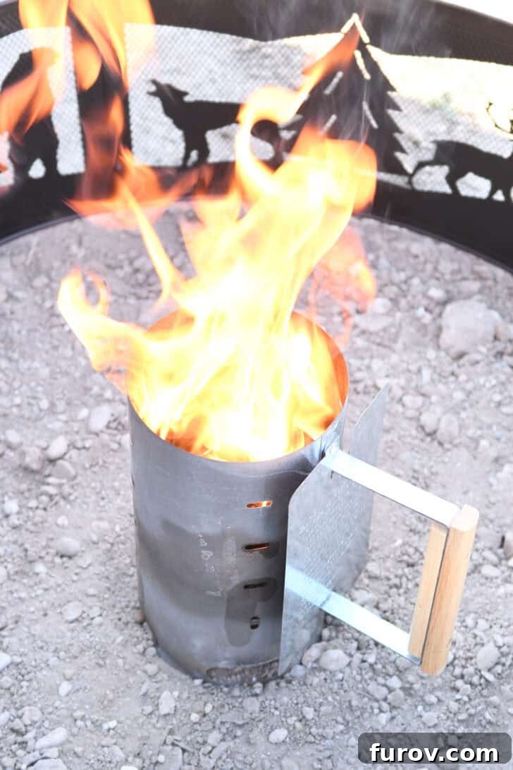 Ultimate Dutch Oven Lasagna 11 Flames erupting from the top of a chimney starter, indicating briquettes are lighting.
