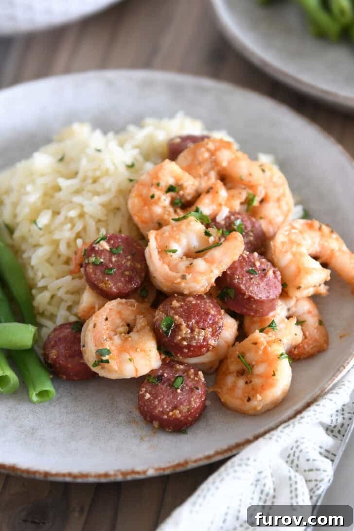 Garlic Butter Shrimp and Sausage Skillet 2 Hearty serving of skillet garlic butter shrimp and sausage with rice on a gray stone plate.