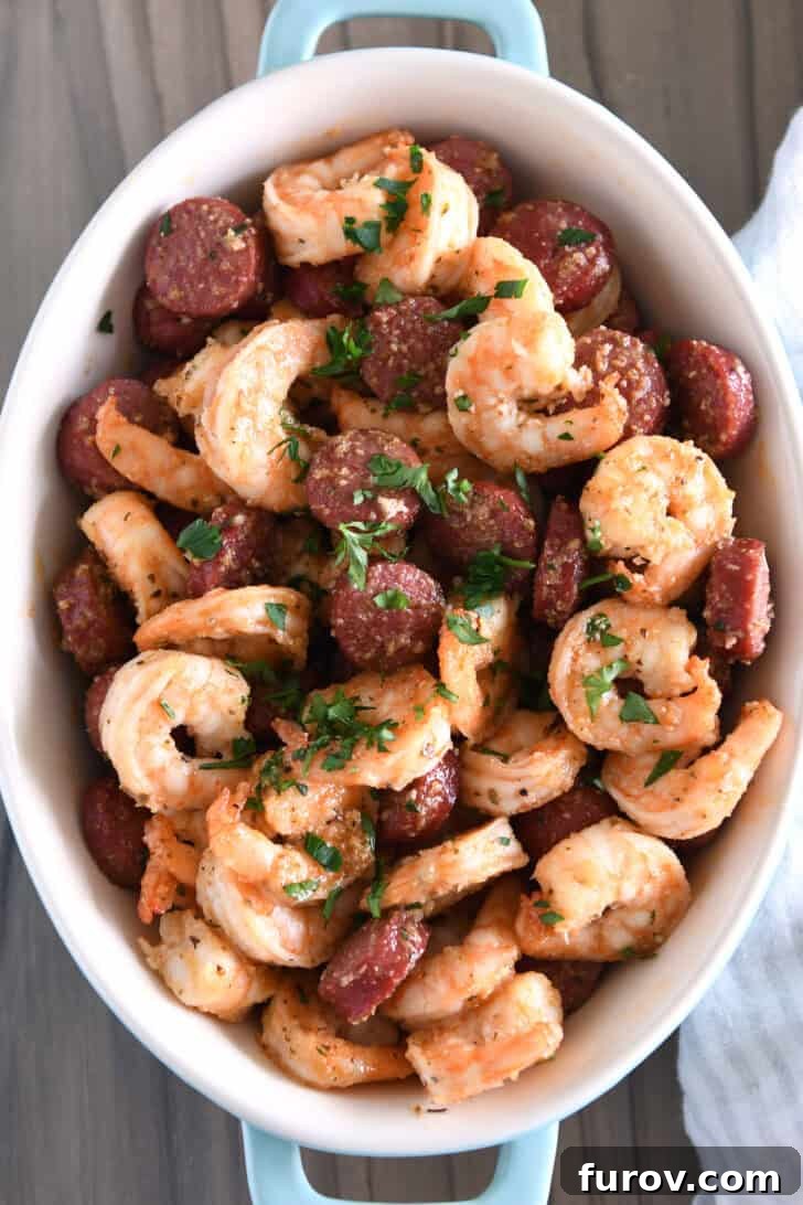 Garlic Butter Shrimp and Sausage Skillet 7 Top-down view of an elegant oval serving dish showcasing perfectly cooked shrimp and sausage, beautifully garnished with fresh parsley.