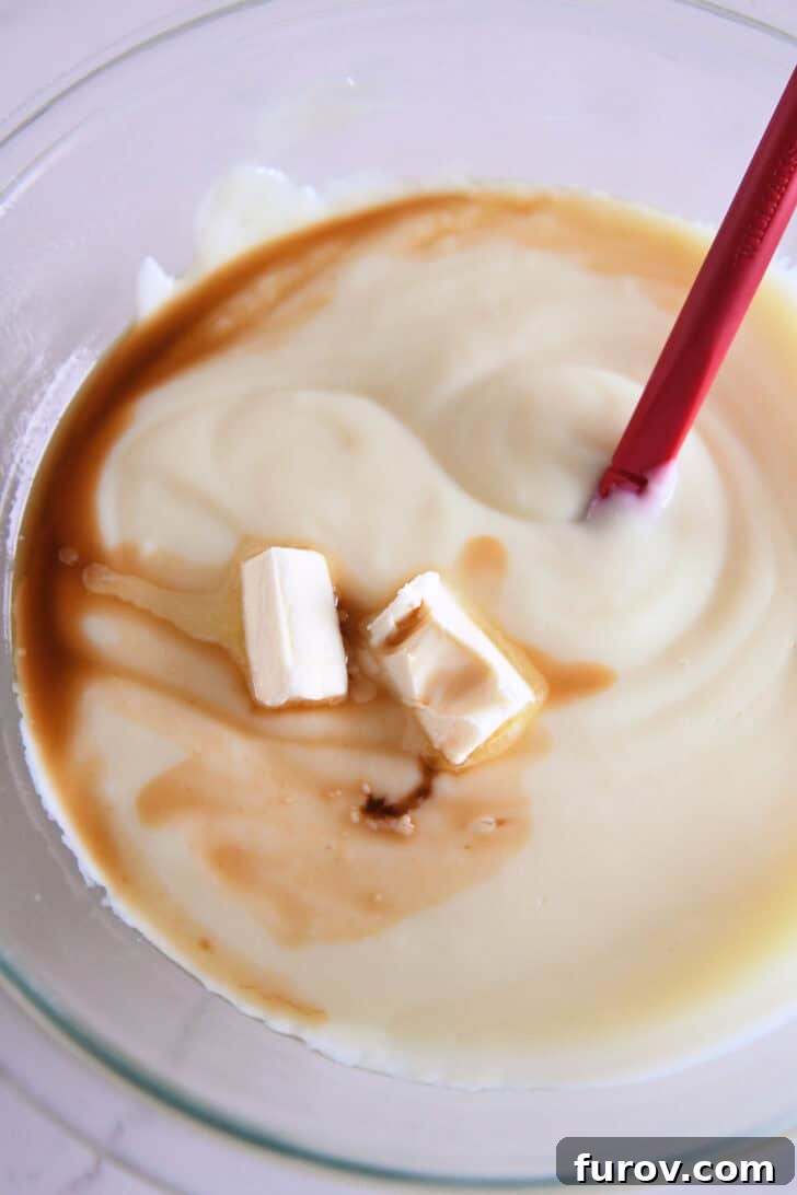 Cooked pudding with butter and vanilla in glass bowl.