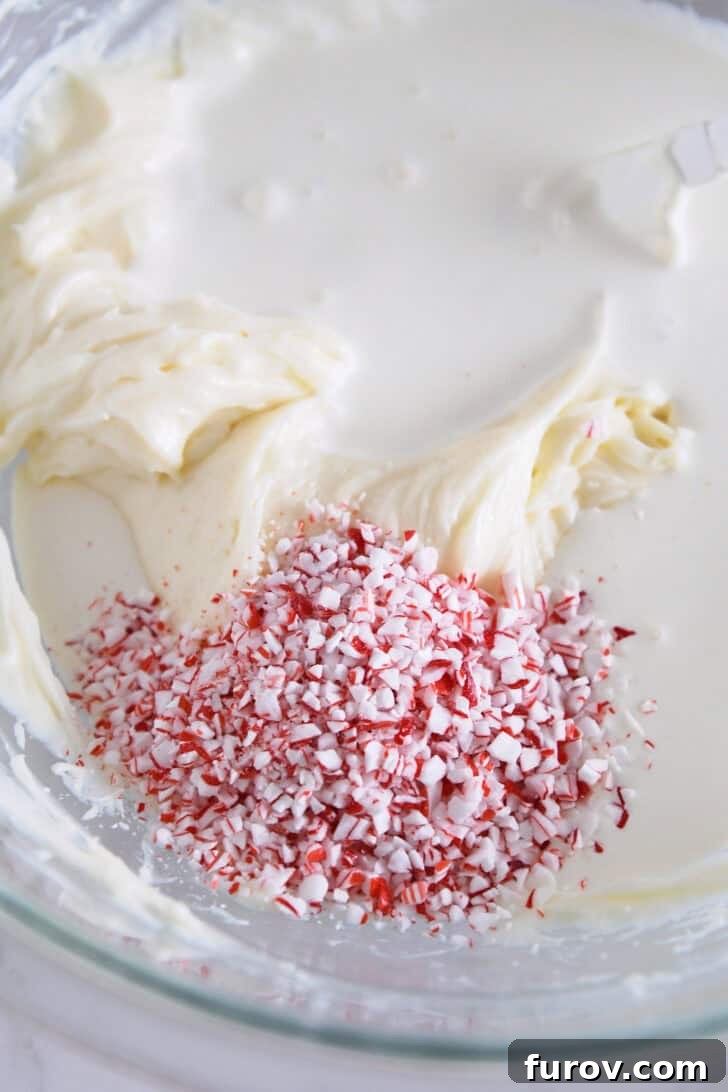 Peppermint pieces in bowl with heavy cream and cream cheese.