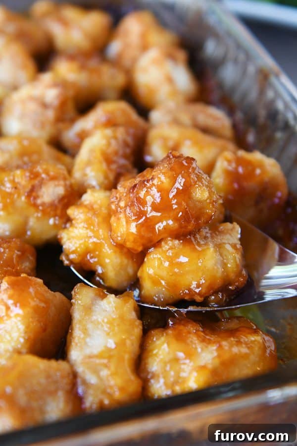 Tangy Honey Glazed Chicken 2 A generous scoop of golden-brown baked sweet and sour chicken, fresh from the pan.