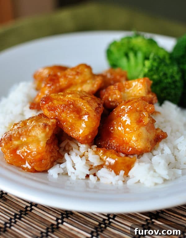 Tangy Honey Glazed Chicken 13 A beautifully plated serving of homemade sweet and sour chicken on rice, accompanied by a vibrant side of broccoli.