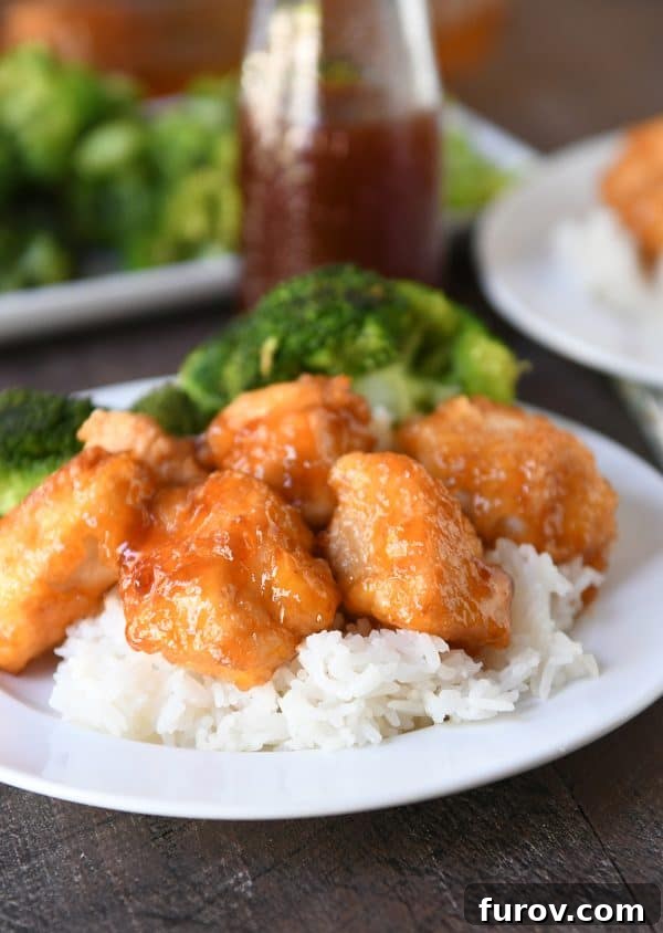 Tangy Honey Glazed Chicken 3 Succulent pieces of baked sweet and sour chicken served over fluffy white rice with a side of vibrant steamed broccoli.