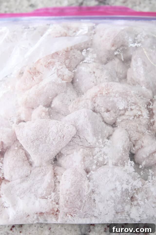 Tangy Honey Glazed Chicken 5 Chicken pieces fully coated in cornstarch within a sealed ziploc bag.