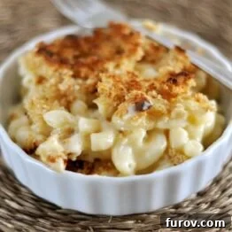 A small ramekin of golden baked macaroni and cheese with a crispy topping, ready to be served.