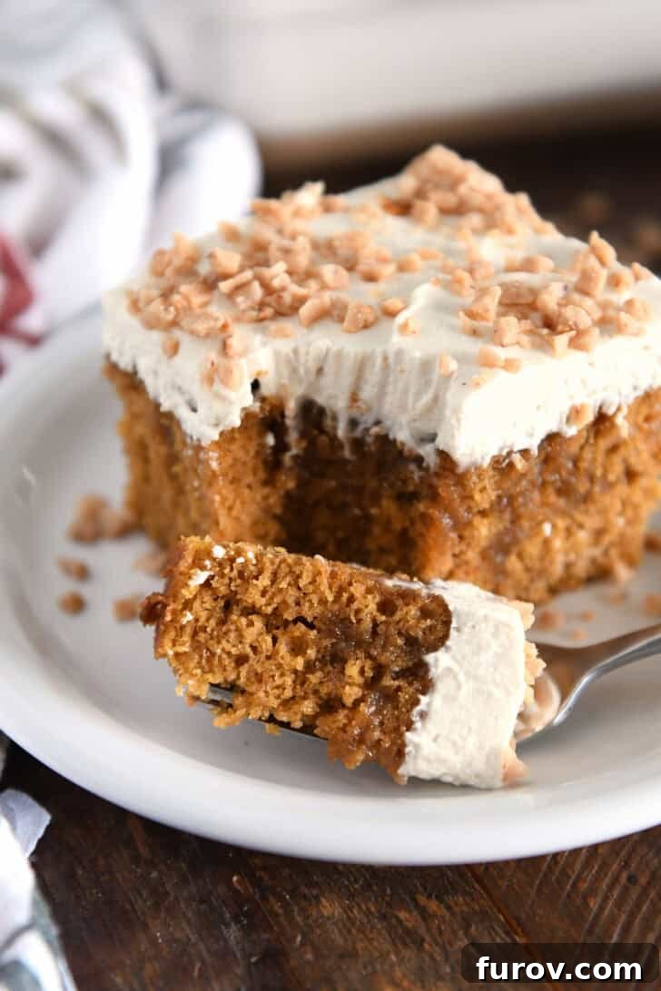 Caramel-Soaked Pumpkin Poke Cake with Whipped Caramel Topping 18 A fork holding a bite of pumpkin caramel poke cake, placed next to a square slice of the cake on a white plate, ready to be enjoyed.